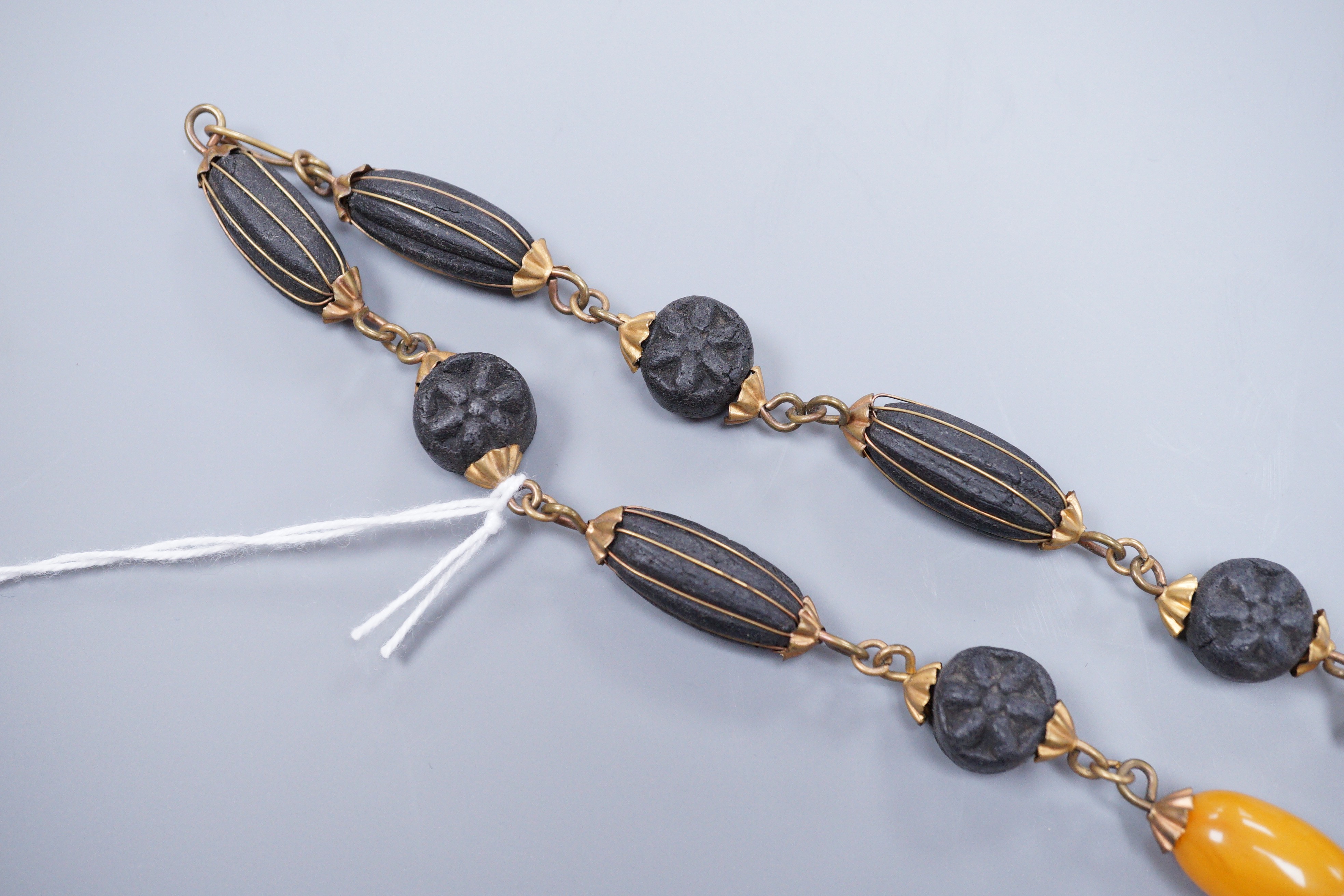 A 1930's gilt brass mounted composition and simulated amber bead necklace, 40cm